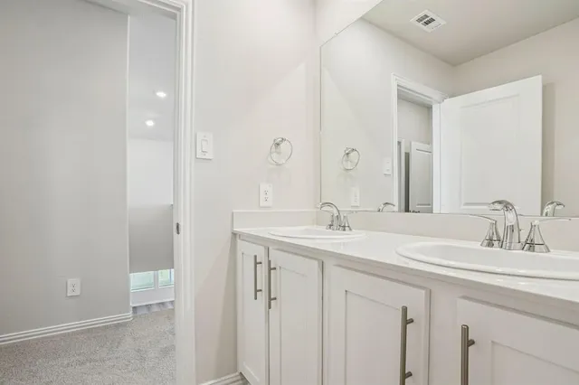 a bathroom with a double vanity sink and a mirror
