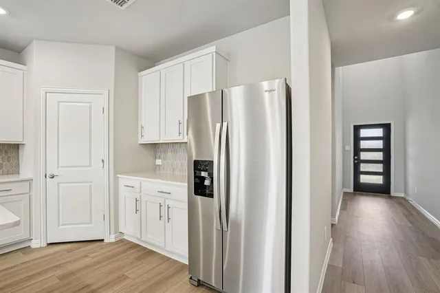 a kitchen with stainless steel appliances a refrigerator and wooden floor