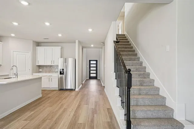 a view of a kitchen with wooden floor and electronic appliances