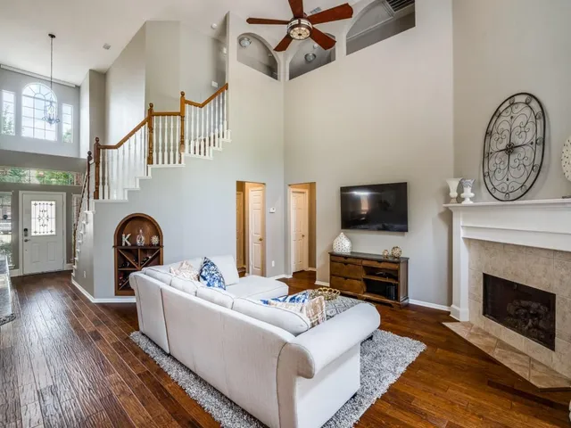 a living room with furniture a flat screen tv and a fireplace