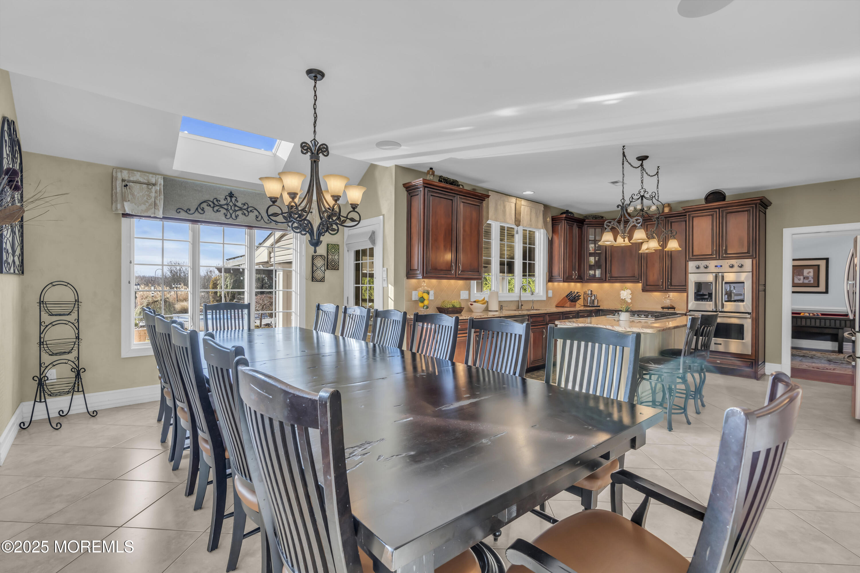12 Courtney Court Freehold, NJ 07728 - Photo 12 of 99 a dining room with wooden floor a chandelier a glass table and chairs