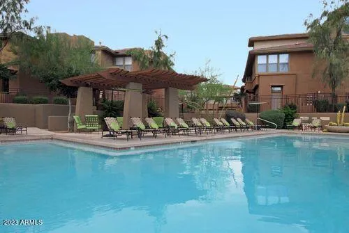 a view of a swimming pool with a table and chairs under an umbrella
