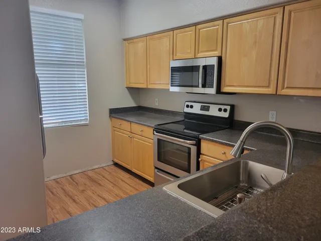 a kitchen with stainless steel appliances granite countertop a stove a sink and a microwave