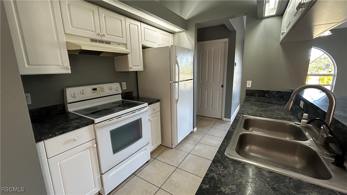 2811 40th Street Southwest Lehigh Acres, FL 33976 - Photo 4 of 13 a kitchen with a stove and a refrigerator