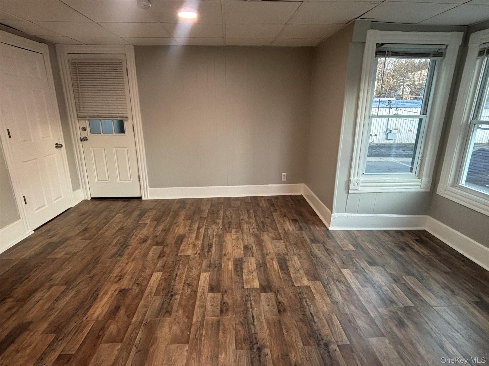 114 Sprague Avenue, Unit 2 Middletown, NY 10940 - Photo 3 of 13 Spare room featuring dark wood-style floors and a drop ceiling