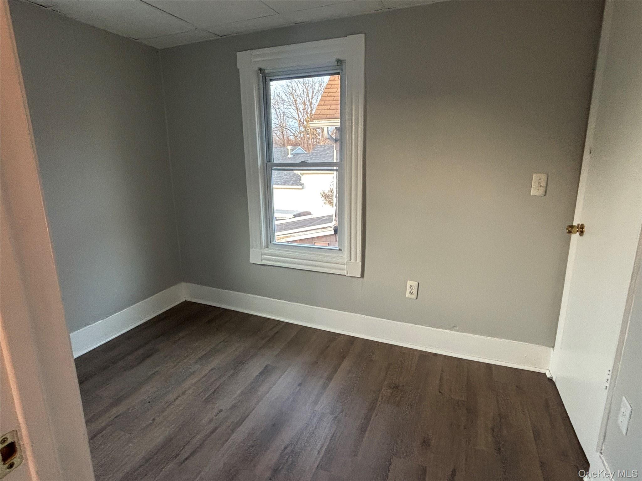 114 Sprague Avenue, Unit 2 Middletown, NY 10940 - Photo 9 of 13 Spare room with dark wood-style flooring and a drop ceiling