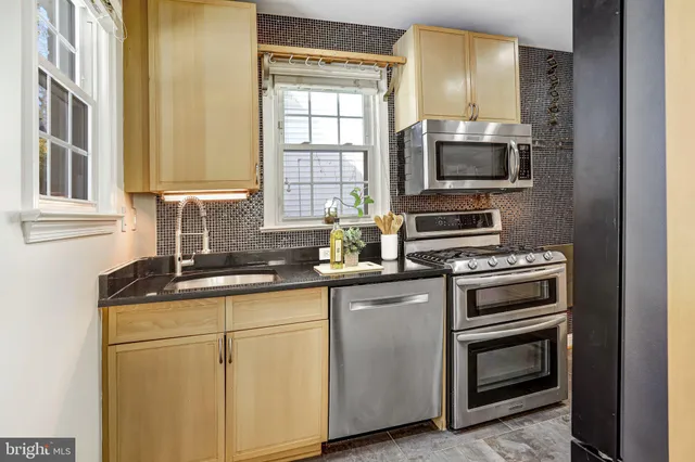 a kitchen with stainless steel appliances granite countertop a refrigerator and a stove top oven