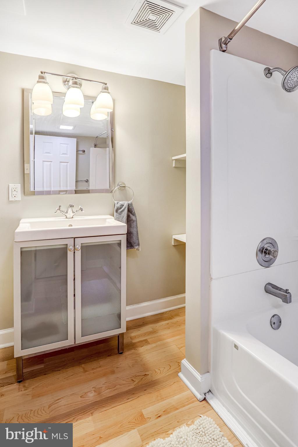 2708 Sycamore Street Alexandria, VA 22305 - Photo 45 of 71 a bathroom with a tub sink vanity and mirror