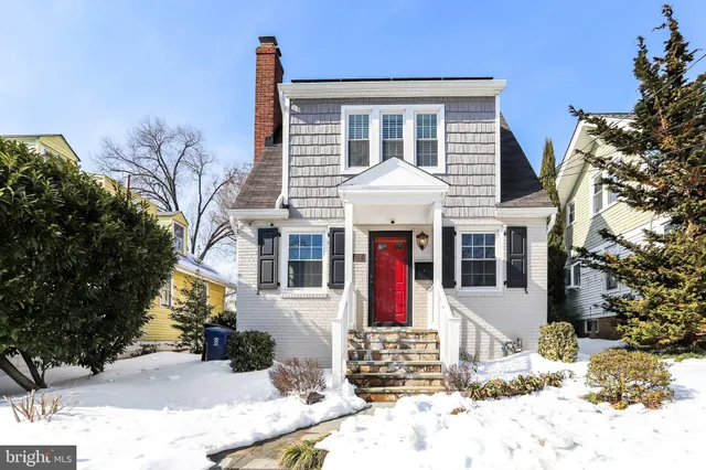 a front view of a house with a yard covered in snow