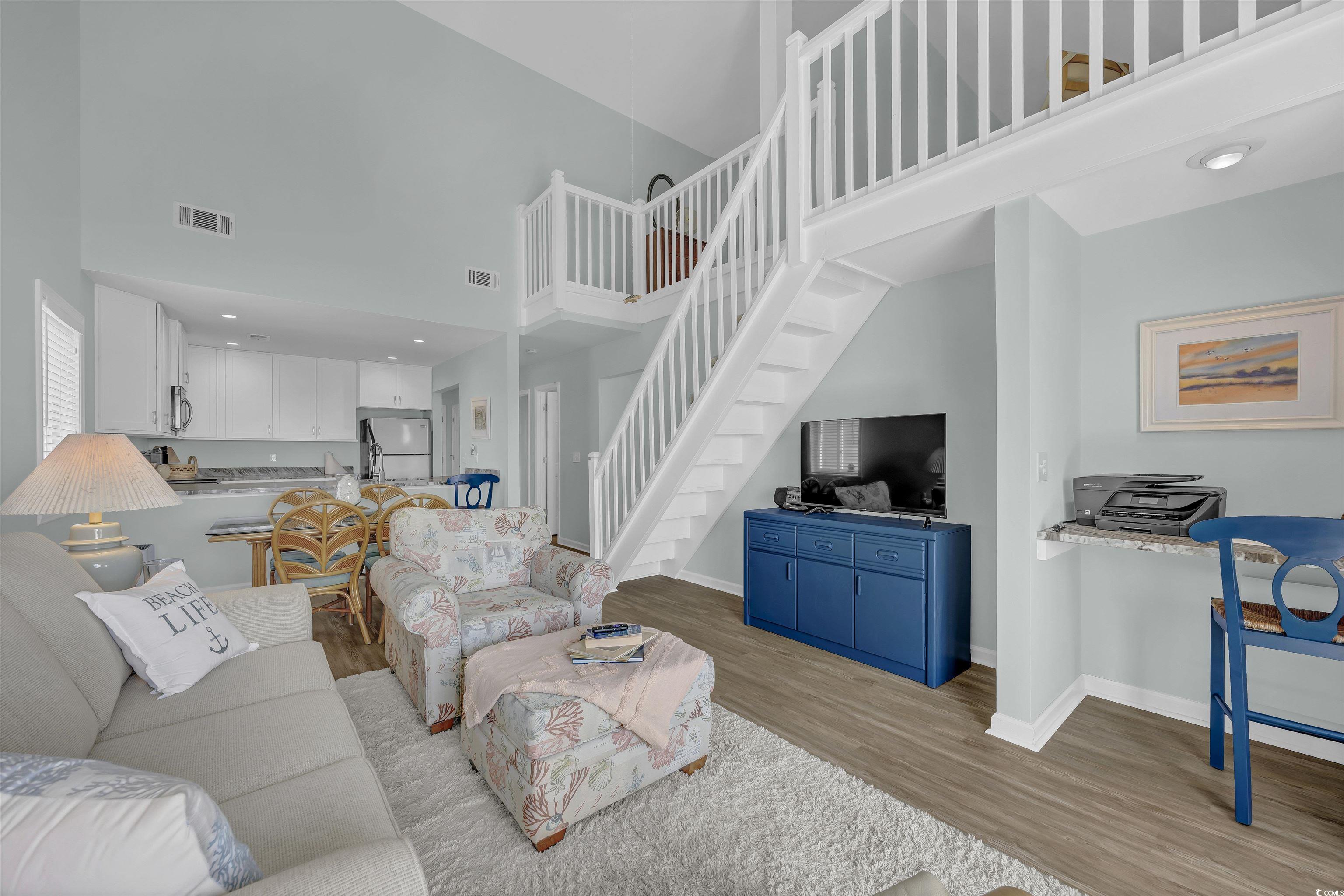 1912 Goose Creek Road Southwest, Unit 4301 Ocean Isle Beach, NC 28469 - Photo 11 of 39 Living area featuring a high ceiling, light wood-style flooring, stairs, and recessed lighting