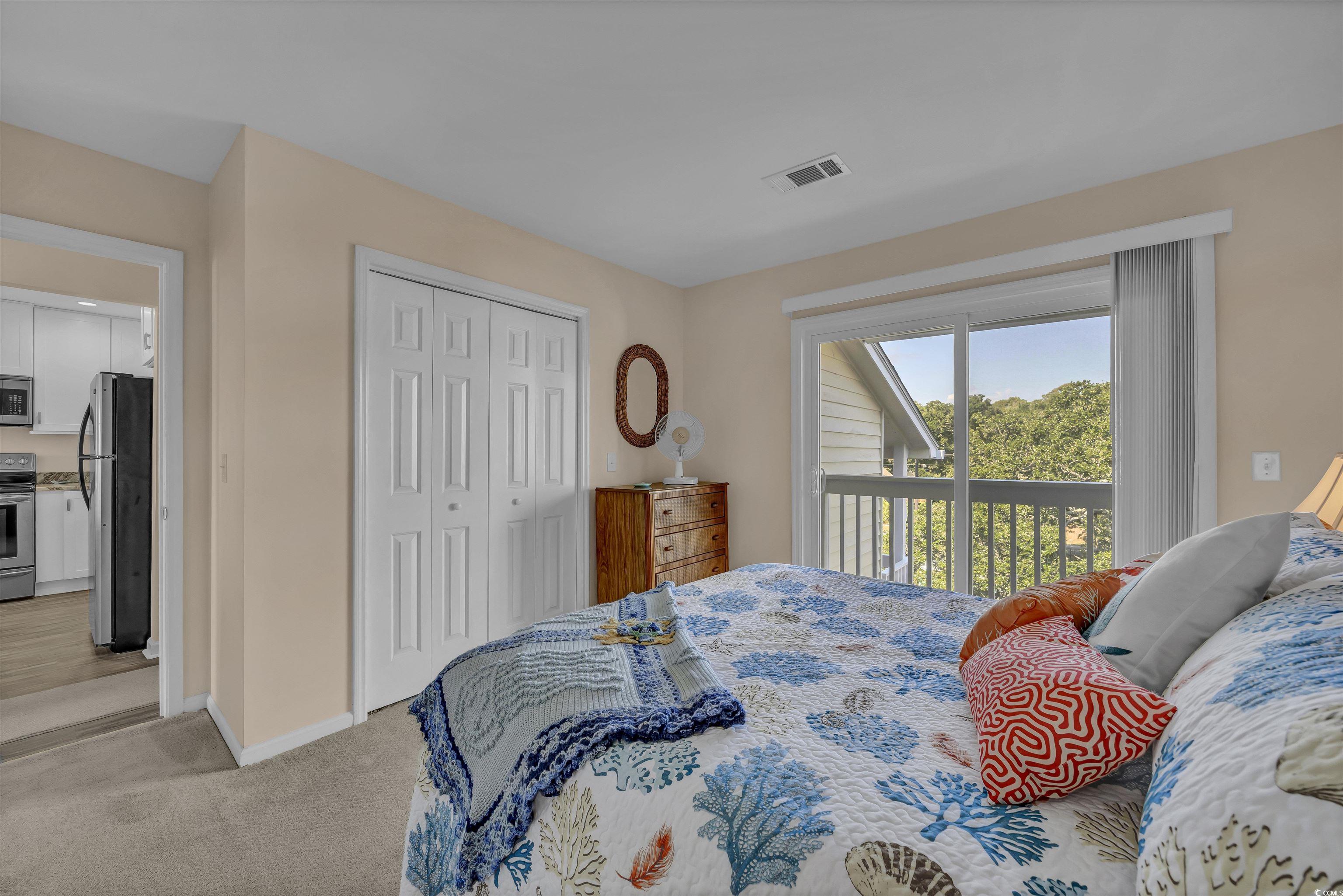 1912 Goose Creek Road Southwest, Unit 4301 Ocean Isle Beach, NC 28469 - Photo 17 of 39 Carpeted bedroom featuring freestanding refrigerator, access to outside, and a closet