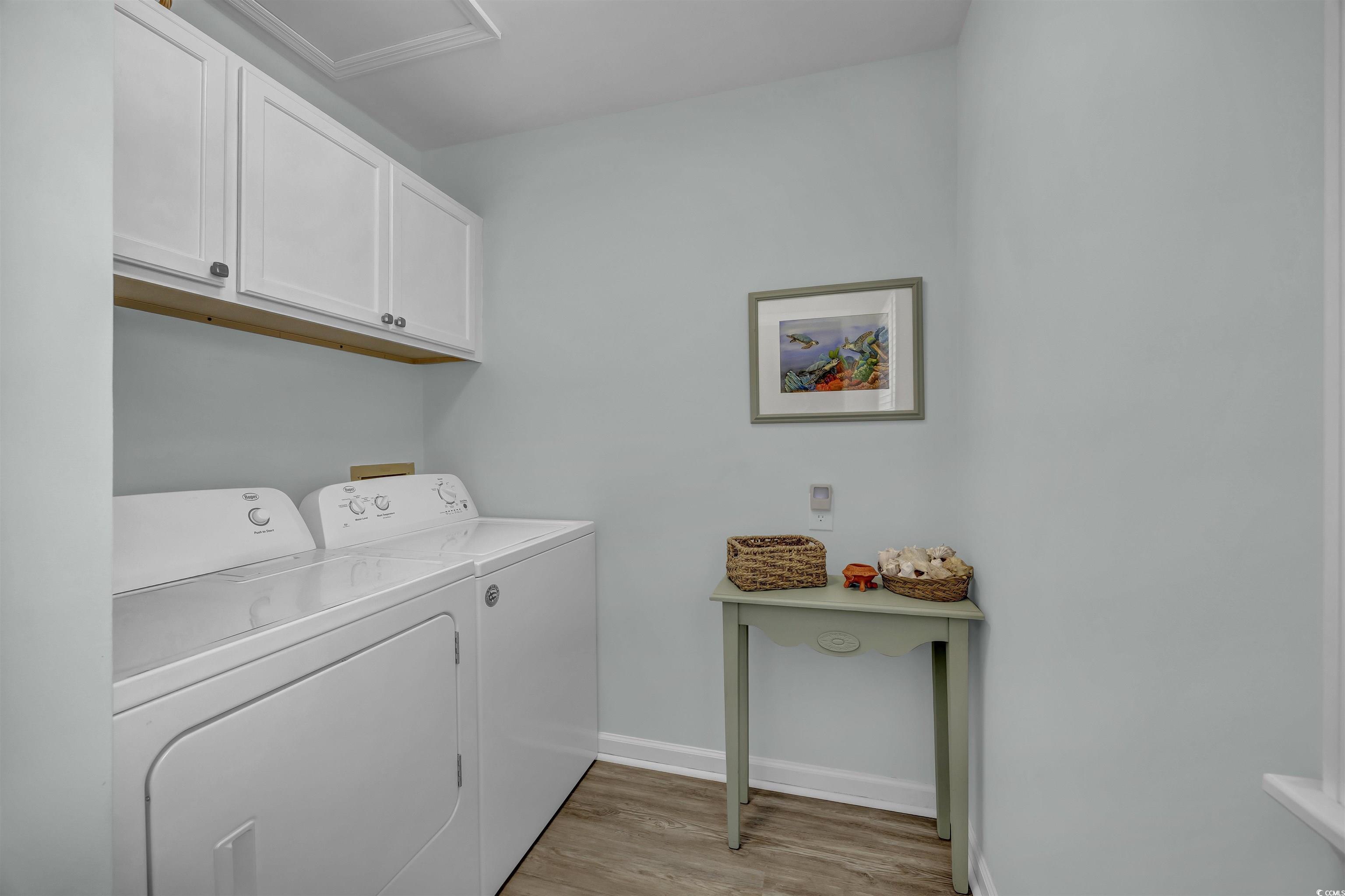 1912 Goose Creek Road Southwest, Unit 4301 Ocean Isle Beach, NC 28469 - Photo 27 of 39 Laundry room with light wood-style floors, cabinet space, and washing machine and clothes dryer