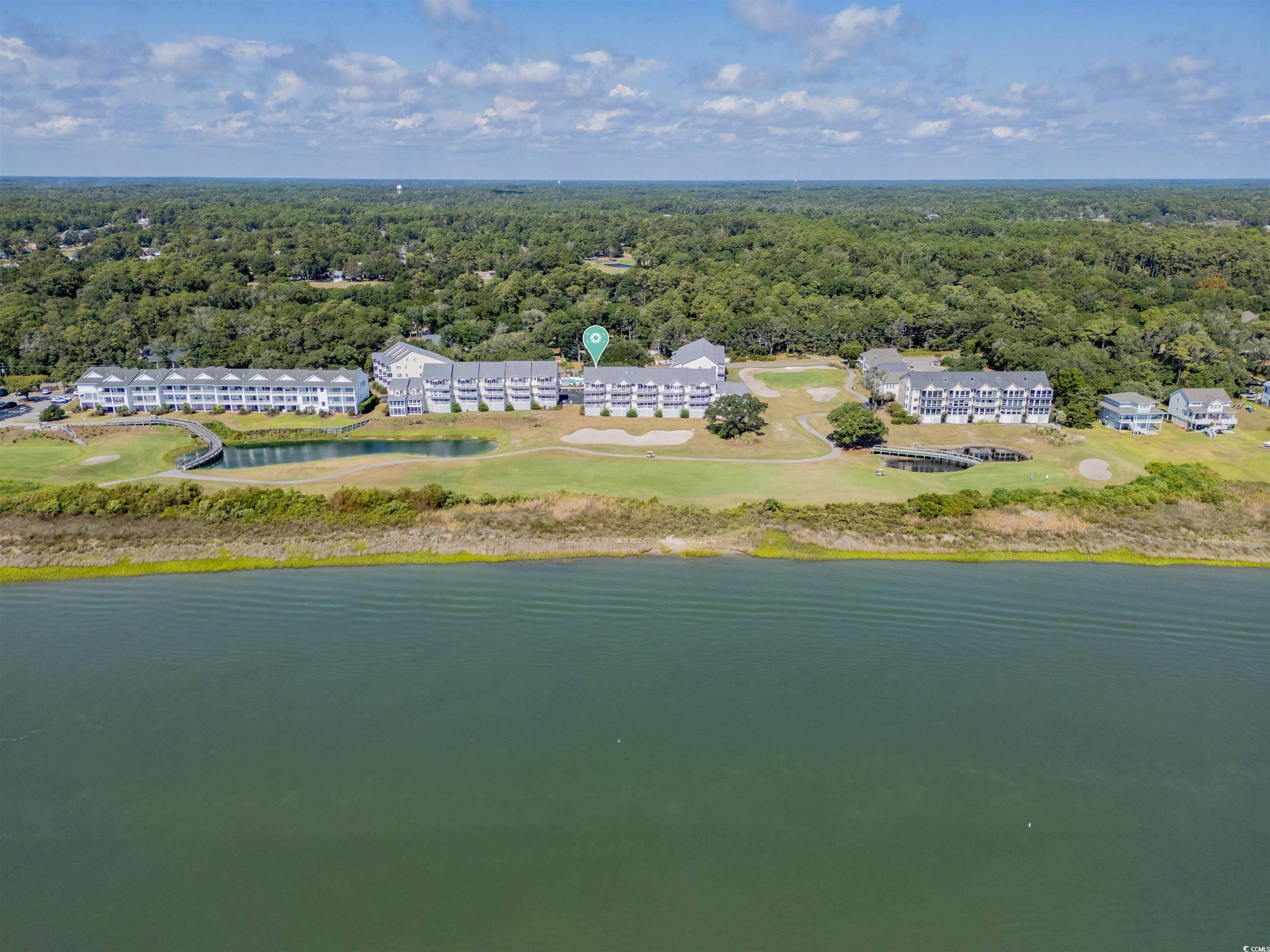 1912 Goose Creek Road Southwest, Unit 4301 Ocean Isle Beach, NC 28469 - Photo 28 of 39 Aerial view of a heavily wooded area and a nearby body of water
