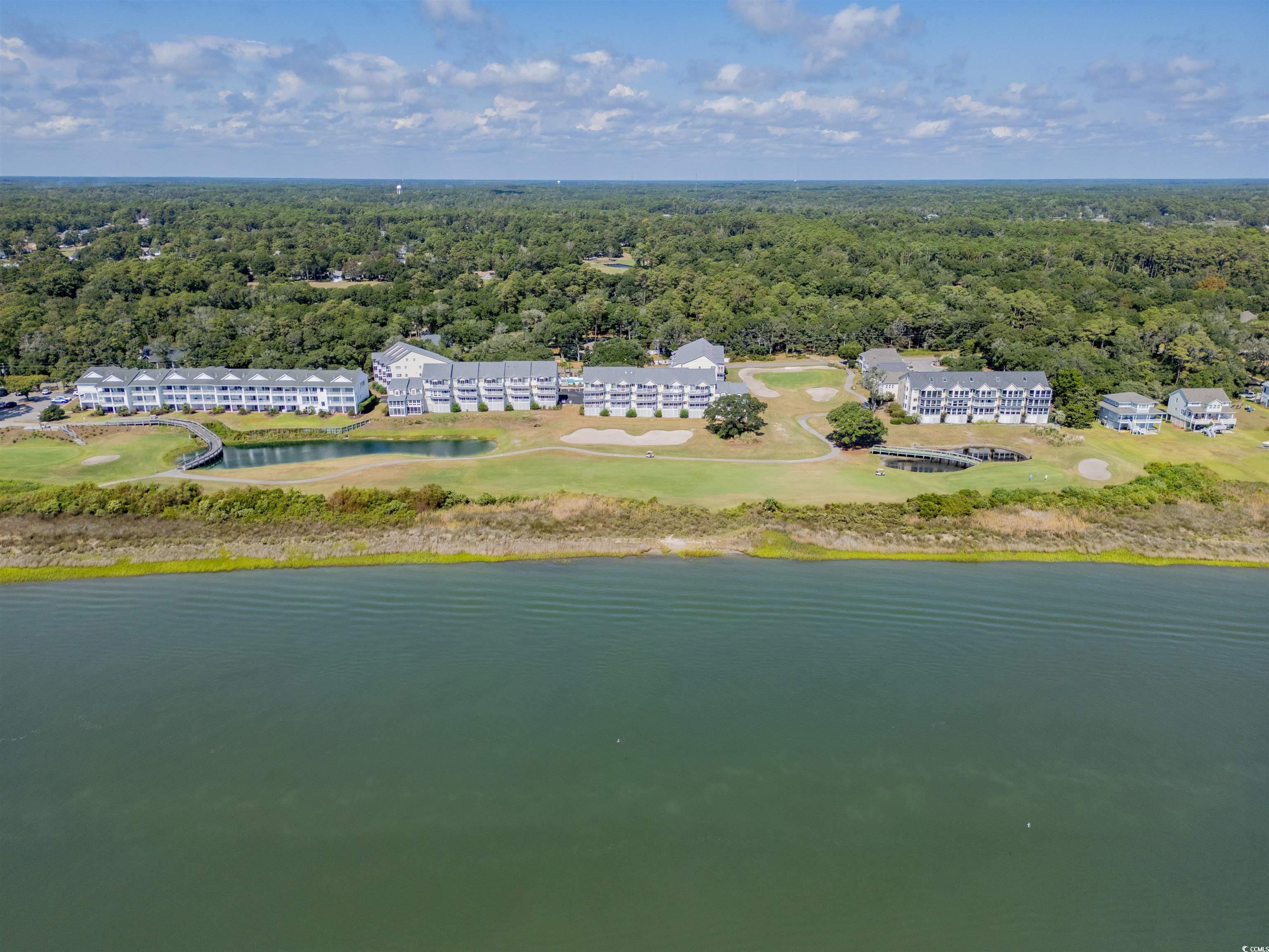 1912 Goose Creek Road Southwest, Unit 4301 Ocean Isle Beach, NC 28469 - Photo 29 of 39 Drone / aerial view of a forest and a large body of water