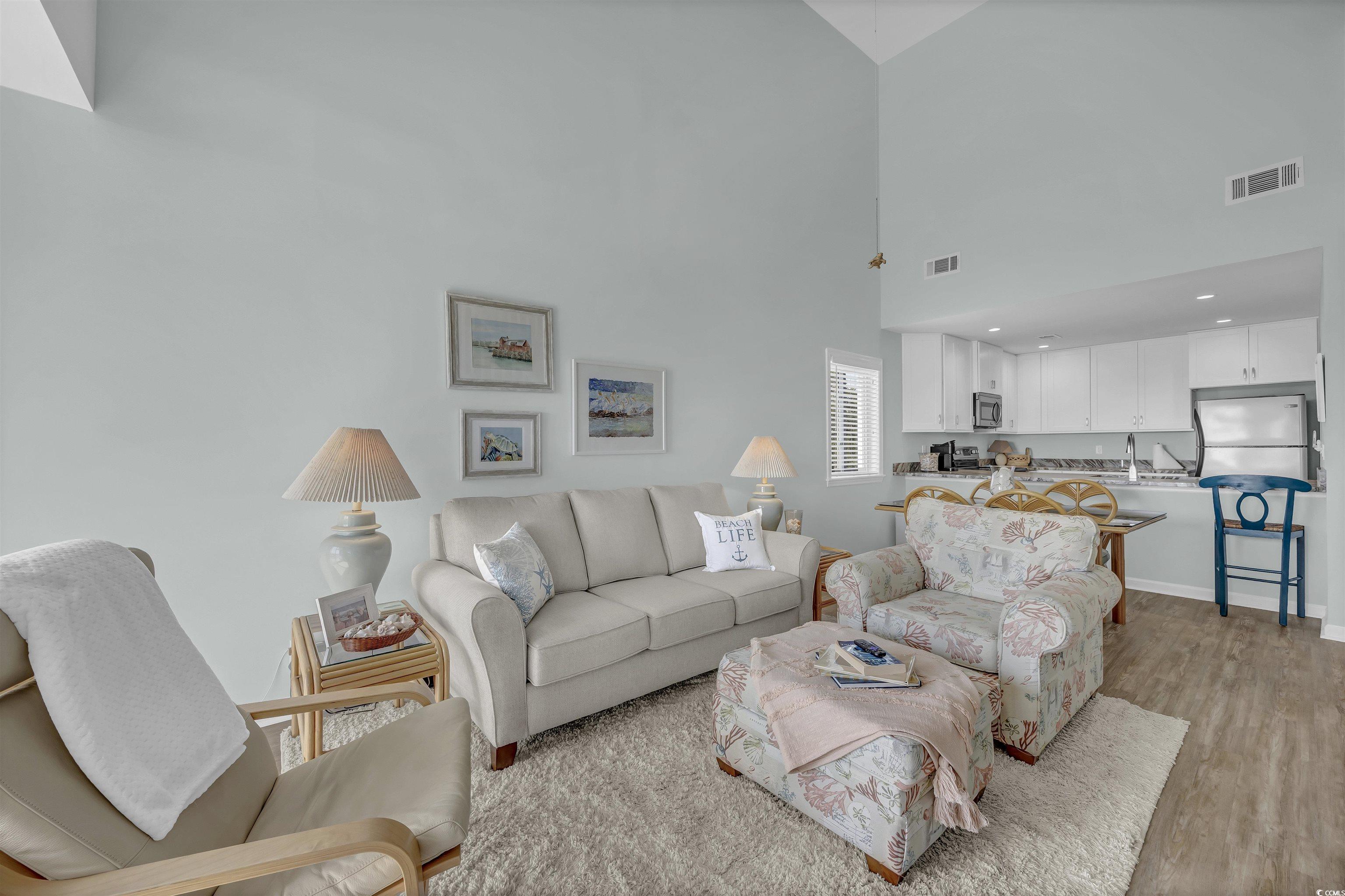 1912 Goose Creek Road Southwest, Unit 4301 Ocean Isle Beach, NC 28469 - Photo 10 of 39 Living room with light wood finished floors and a high ceiling