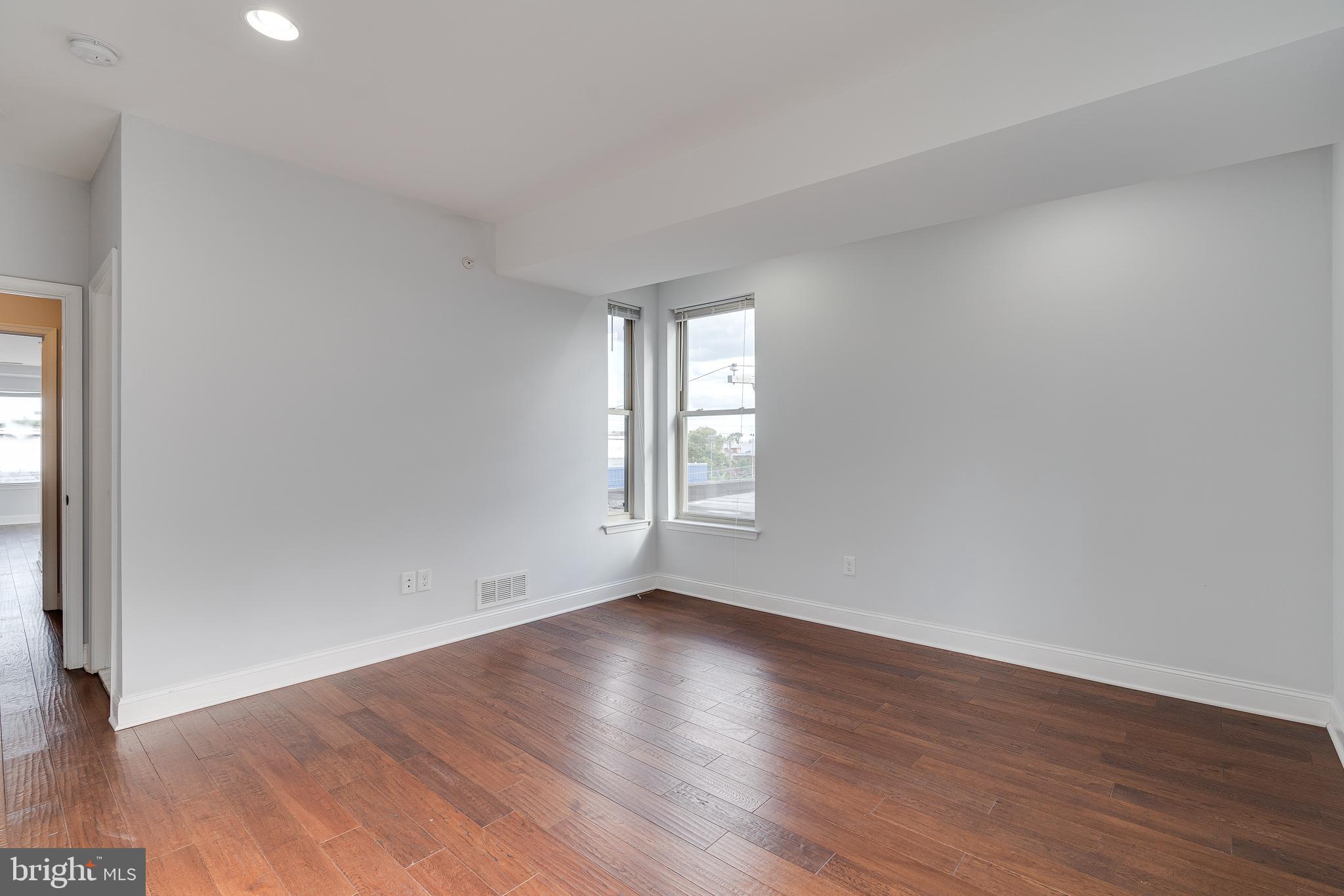 1024 South 19th Street, Unit B Philadelphia, PA 19146 - Photo 17 of 28 an empty room with wooden floor and window