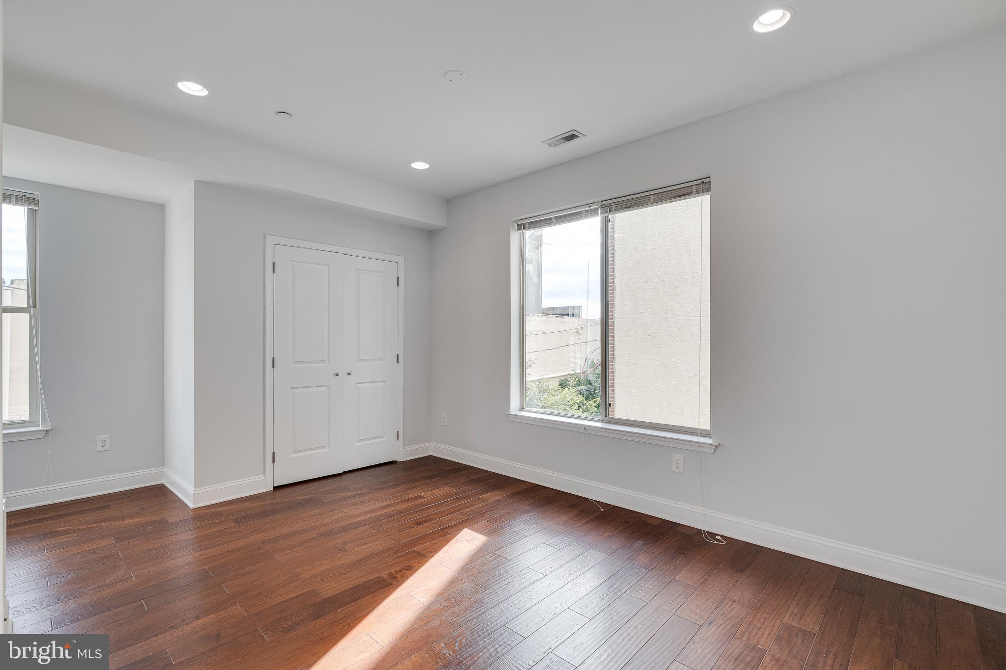 1024 South 19th Street, Unit B Philadelphia, PA 19146 - Photo 26 of 28 an empty room with wooden floor and windows