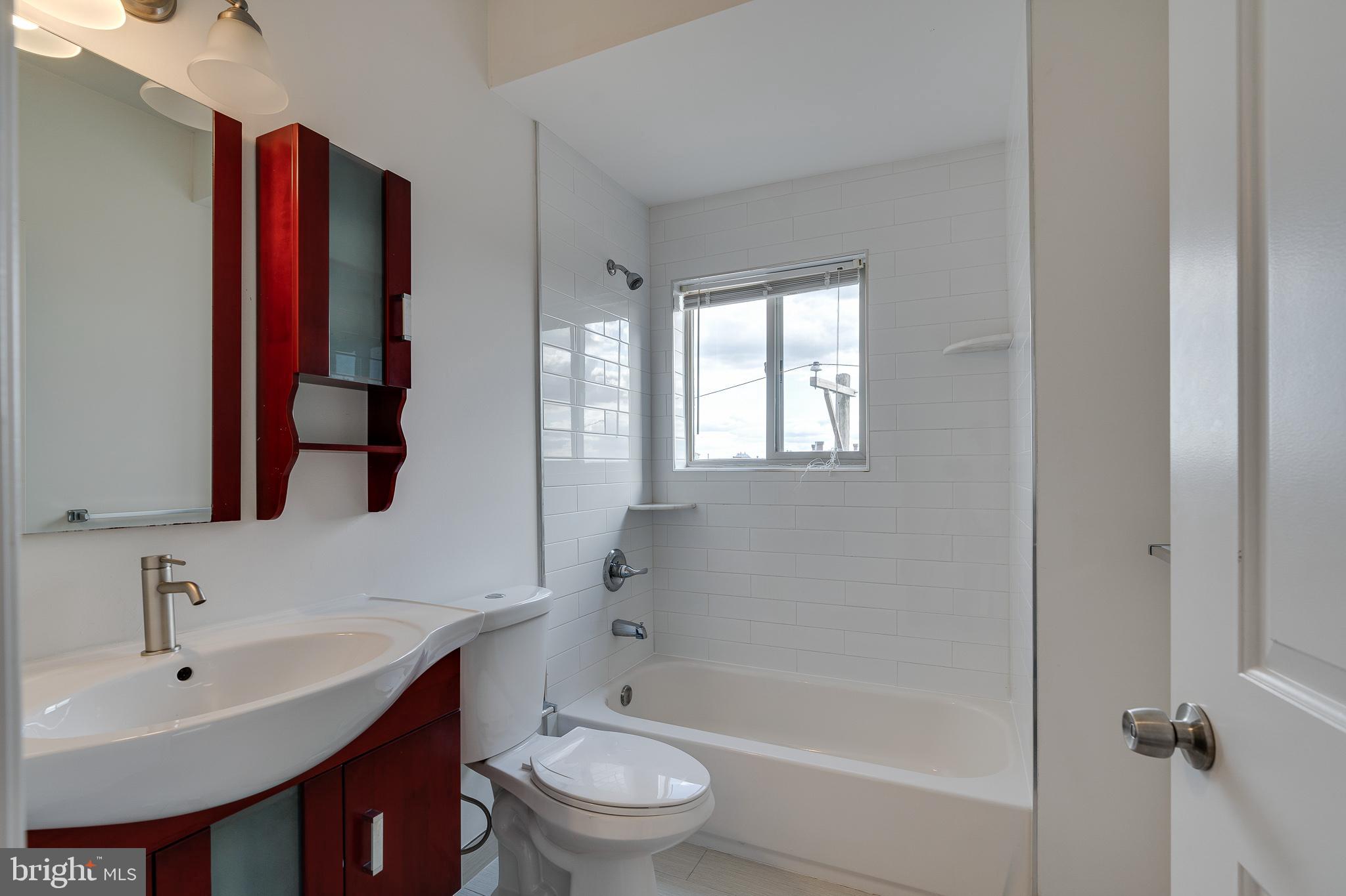 1024 South 19th Street, Unit B Philadelphia, PA 19146 - Photo 27 of 28 a bathroom with a bathtub shower sink vanity mirror and toilet