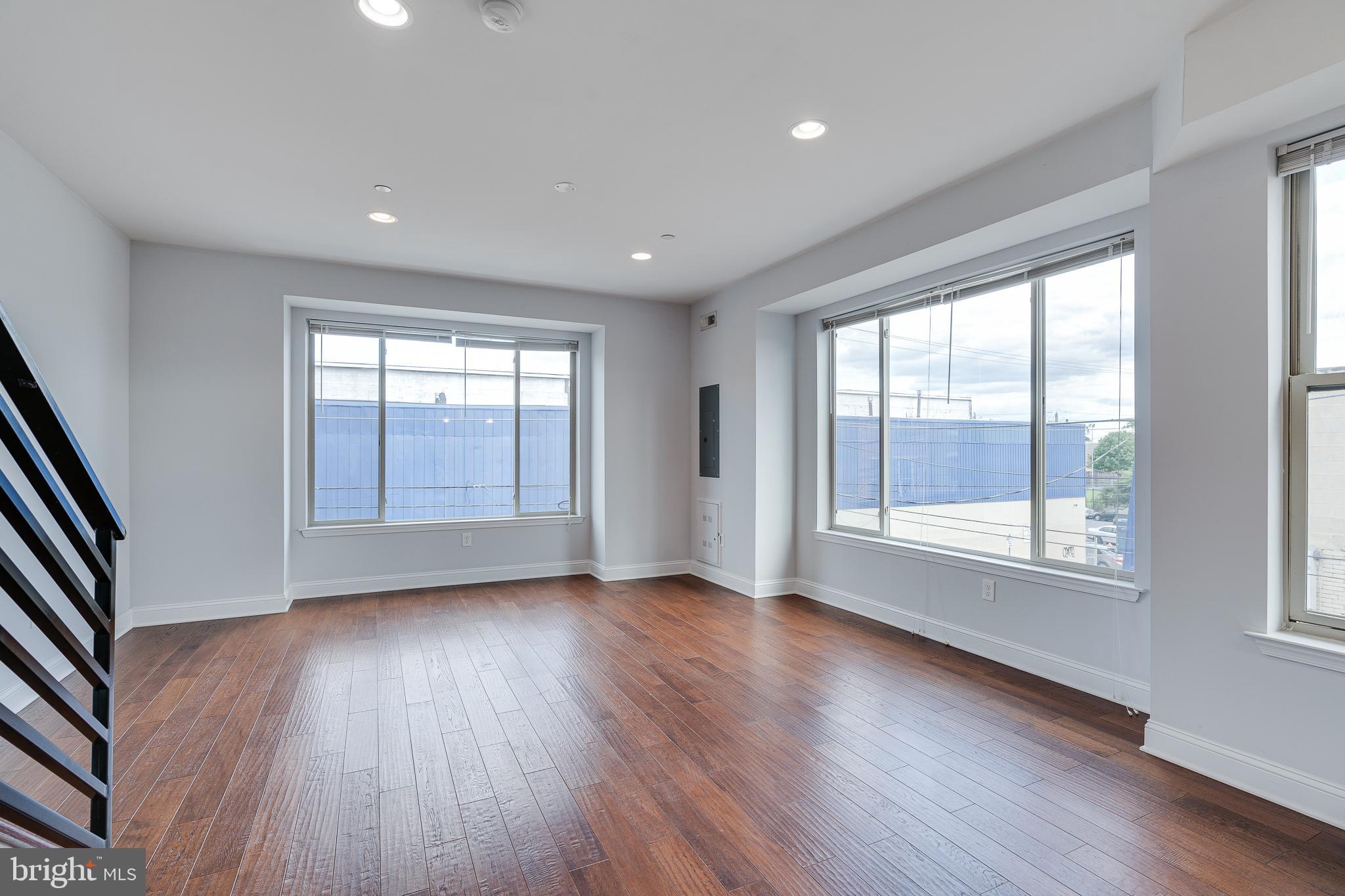 1024 South 19th Street, Unit B Philadelphia, PA 19146 - Photo 8 of 28 an empty room with wooden floor and windows