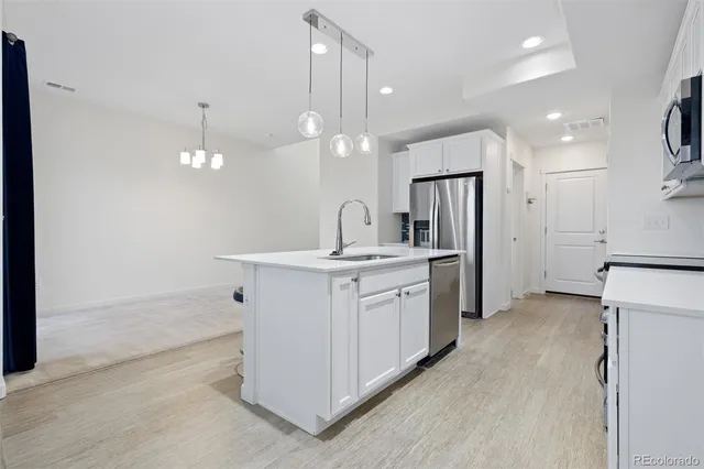 a kitchen with a sink refrigerator and cabinets
