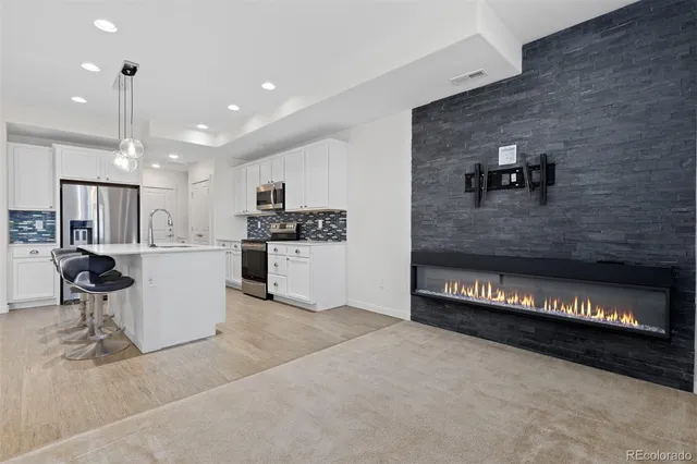 a view of a kitchen with kitchen island and stainless steel appliances