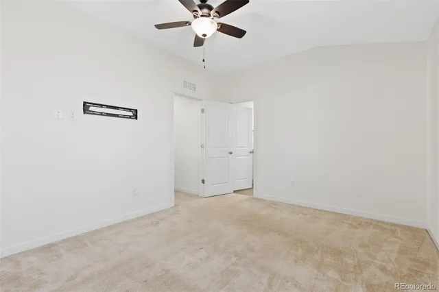 an empty room with a ceiling fan and window