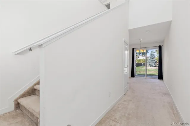 a view of a hallway with a white walls and a window