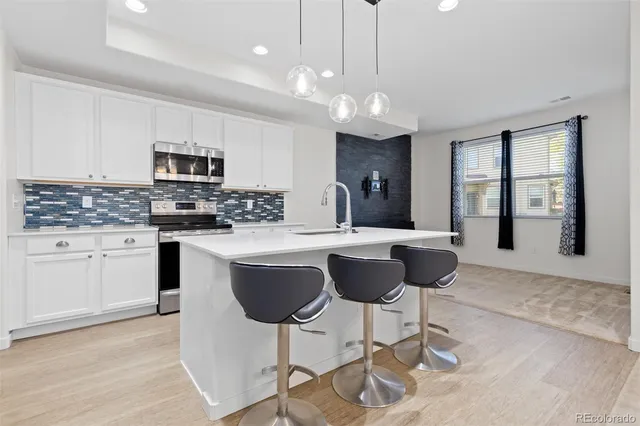 a kitchen with kitchen island granite countertop a sink and cabinets