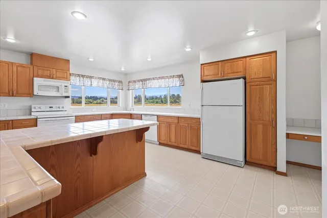 a kitchen with stainless steel appliances granite countertop a sink counter space cabinets and a large window