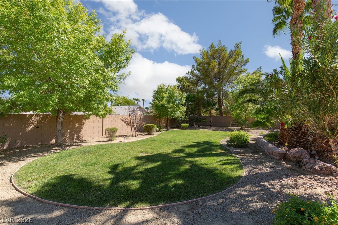 4670 Los Rancheros Avenue Las Vegas, NV 89129 - Photo 46 of 57 Mature trees and a manicured lawn create a peaceful outdoor retreat.