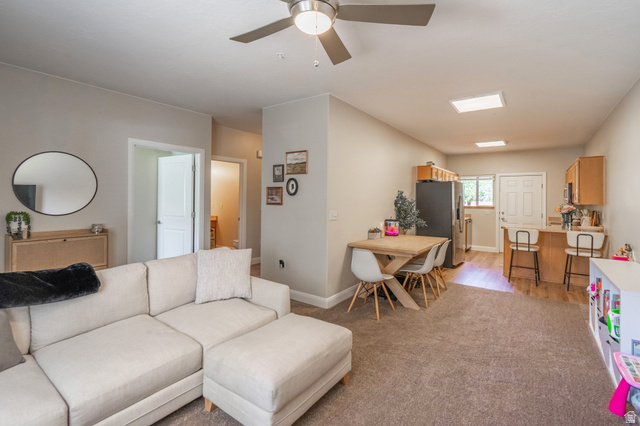 700 North Main Street, Unit F3 Washington, UT 84780 - Photo 6 of 34 Open-concept living space featuring neutral paint colors, a ceiling fan, and carpeted flooring