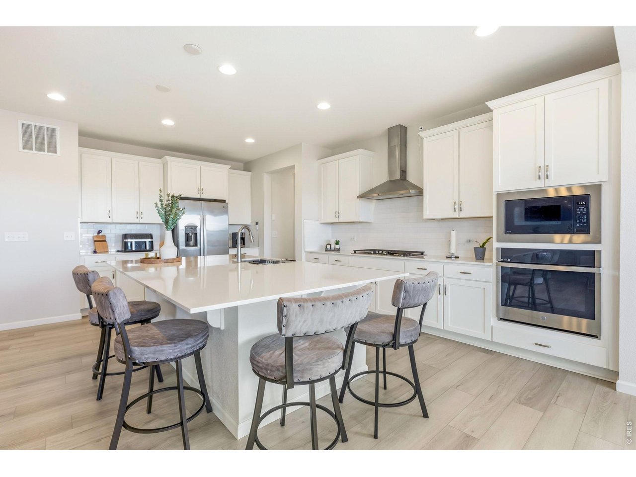 955 Rustling Street Windsor, CO 80550 - Photo 7 of 34 a living room with stainless steel appliances kitchen island granite countertop a dining table chairs and a refrigerator