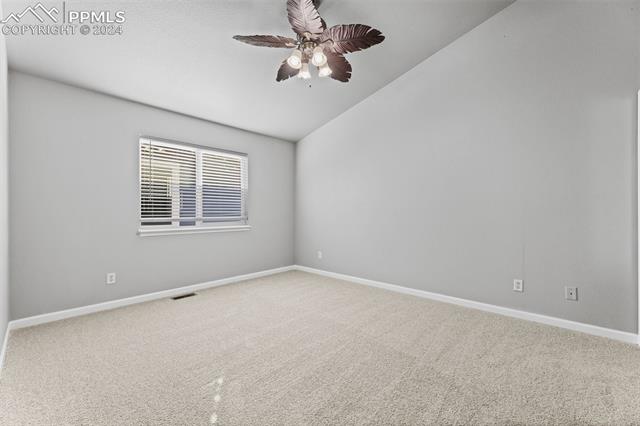 7515 Farmcrest Road Colorado Springs, CO 80925 - Photo 11 of 40 Empty room featuring ceiling fan, carpet floors, and lofted ceiling