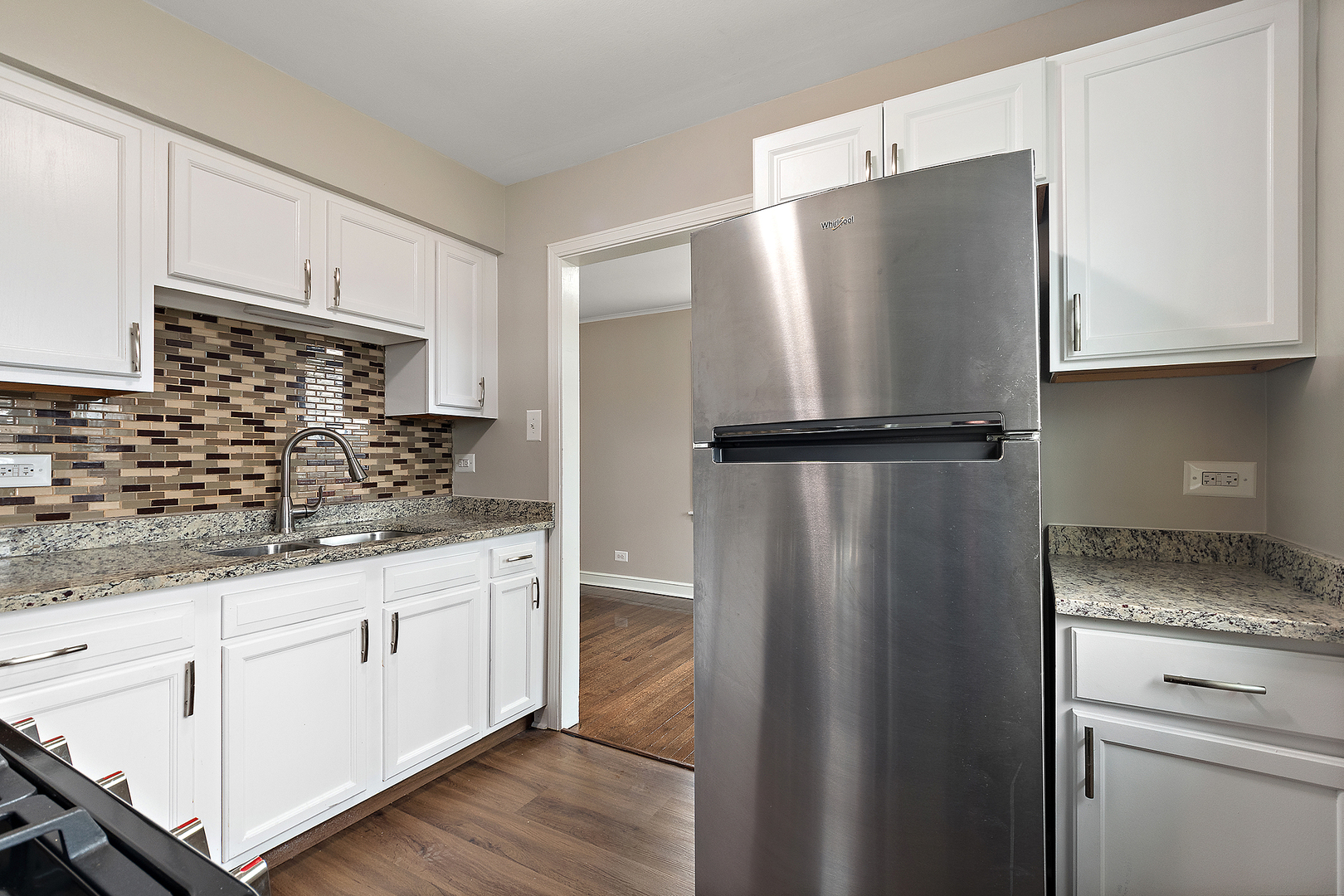1521 North Wolf Road Berkeley, IL 60163 - Photo 8 of 16 a kitchen with stainless steel appliances granite countertop a refrigerator and a sink