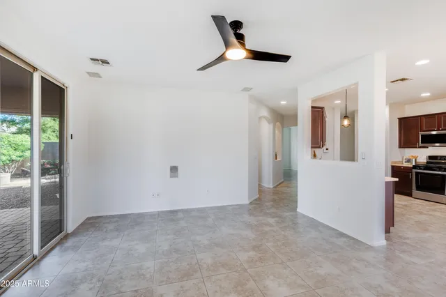 a view of a livingroom with a furniture ceiling fan and window