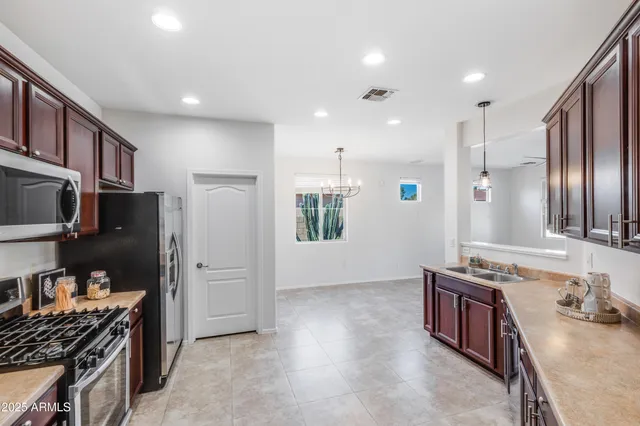 a kitchen with stainless steel appliances granite countertop a refrigerator and a stove