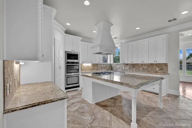 a kitchen with kitchen island granite countertop a stove sink and microwave