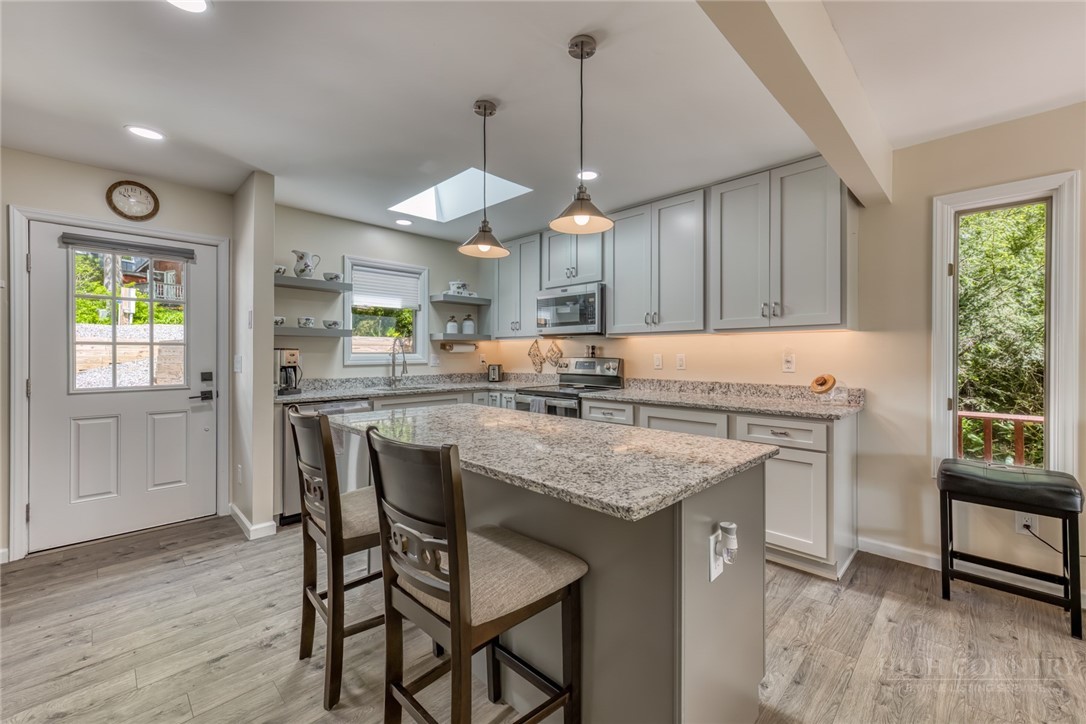 174 Spruce Pine Road Newland, NC 28657 - Photo 13 of 50 a kitchen with a table chairs stove and wooden floor