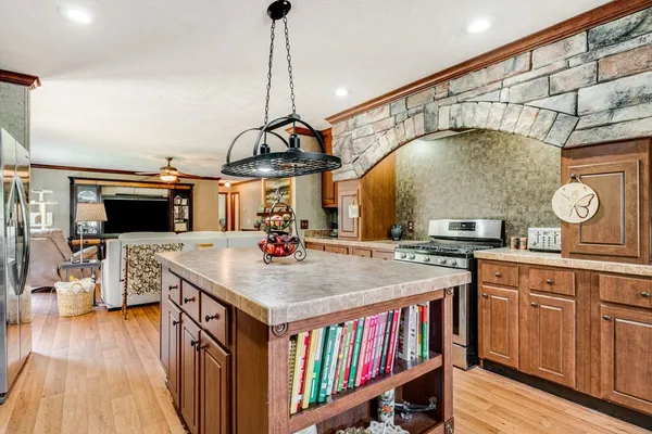 a kitchen with a stove a refrigerator and wooden floor