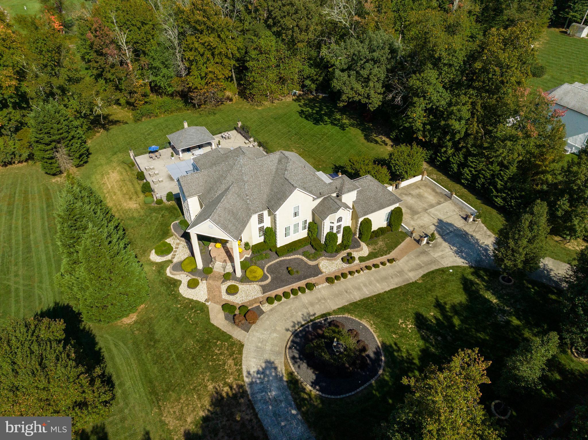 an aerial view of residential house with outdoor space and trees all around