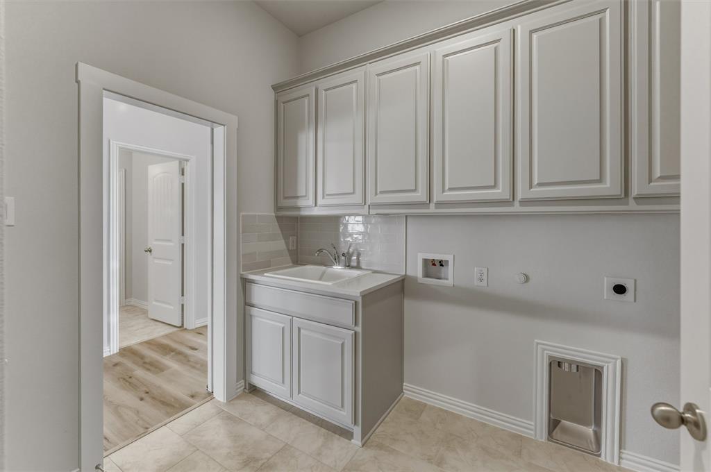 605 Tay Tay Way Springtown, TX 76082 - Photo 23 of 31 Utility space featuring light gray cabinetry, a built-in sink with a countertop, tile flooring, and a subway tile backsplash