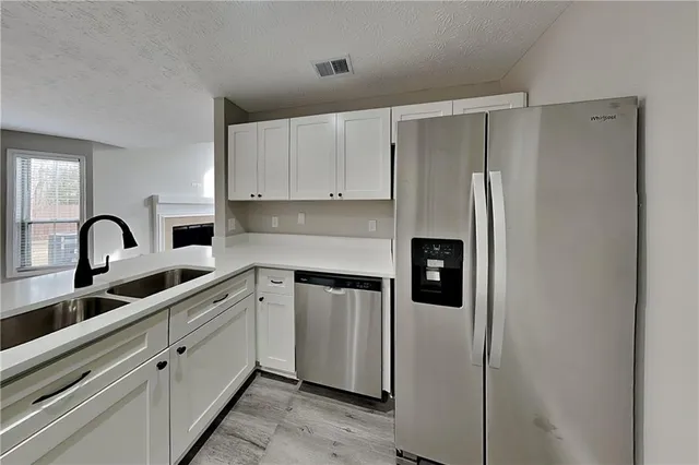 a kitchen with stainless steel appliances granite countertop a refrigerator and a sink