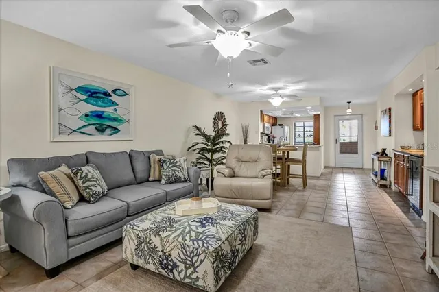 a living room with furniture kitchen view and a chandelier