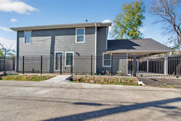 an empty room with wooden floor and kitchen view