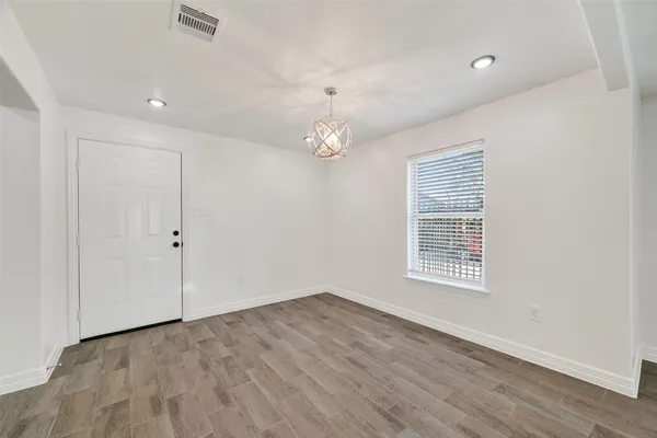 a kitchen with cabinets appliances and wooden floor