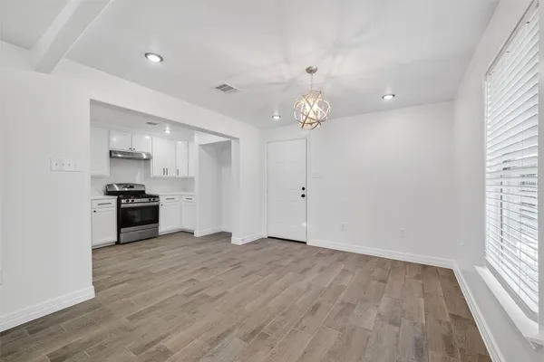 an empty room with wooden floor and white walls