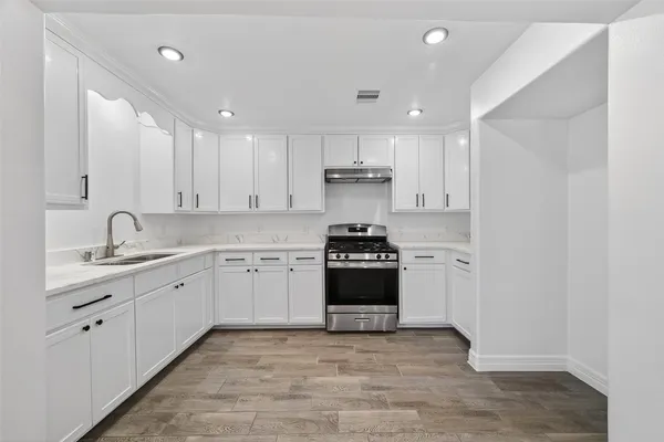 a view of a big room with wooden floor and windows