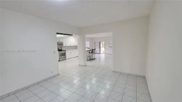 a kitchen with a table chairs a sink dishwasher a refrigerator and cabinets