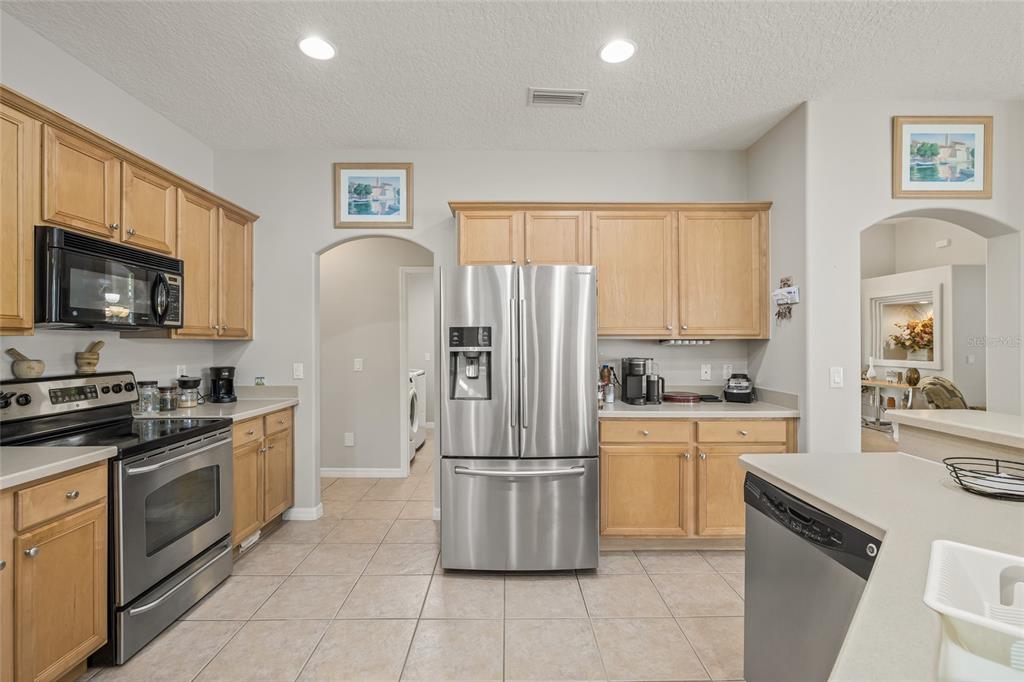 144 Costa Loop Auburndale, FL 33823 - Photo 12 of 34 a kitchen with granite countertop a refrigerator stove and microwave