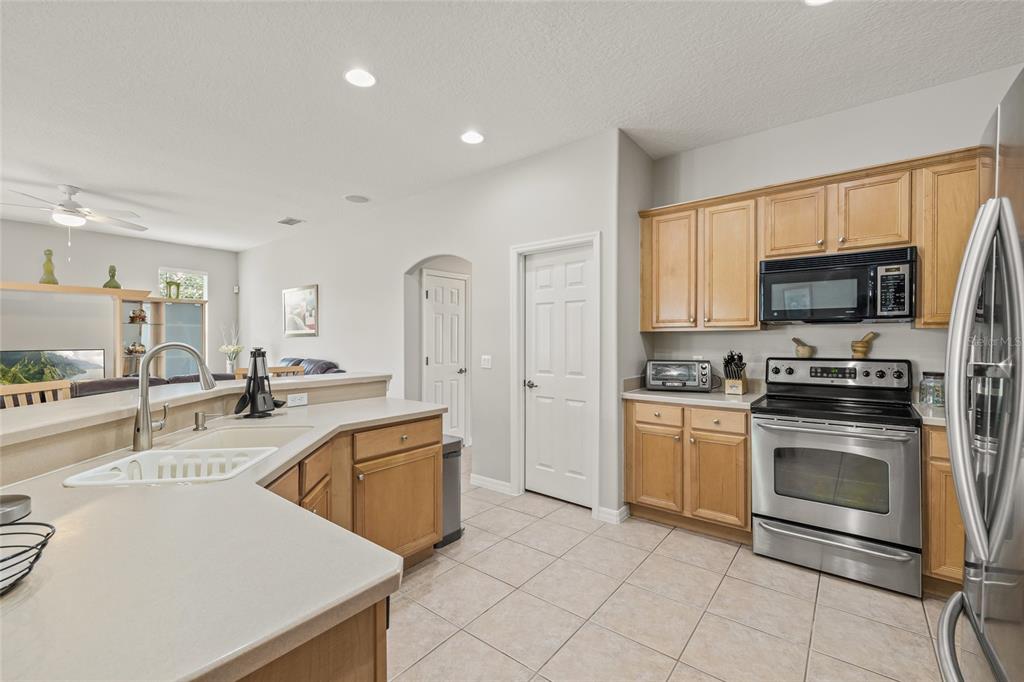144 Costa Loop Auburndale, FL 33823 - Photo 13 of 34 a kitchen with stainless steel appliances granite countertop a stove top oven a sink dishwasher and a refrigerator with cabinets
